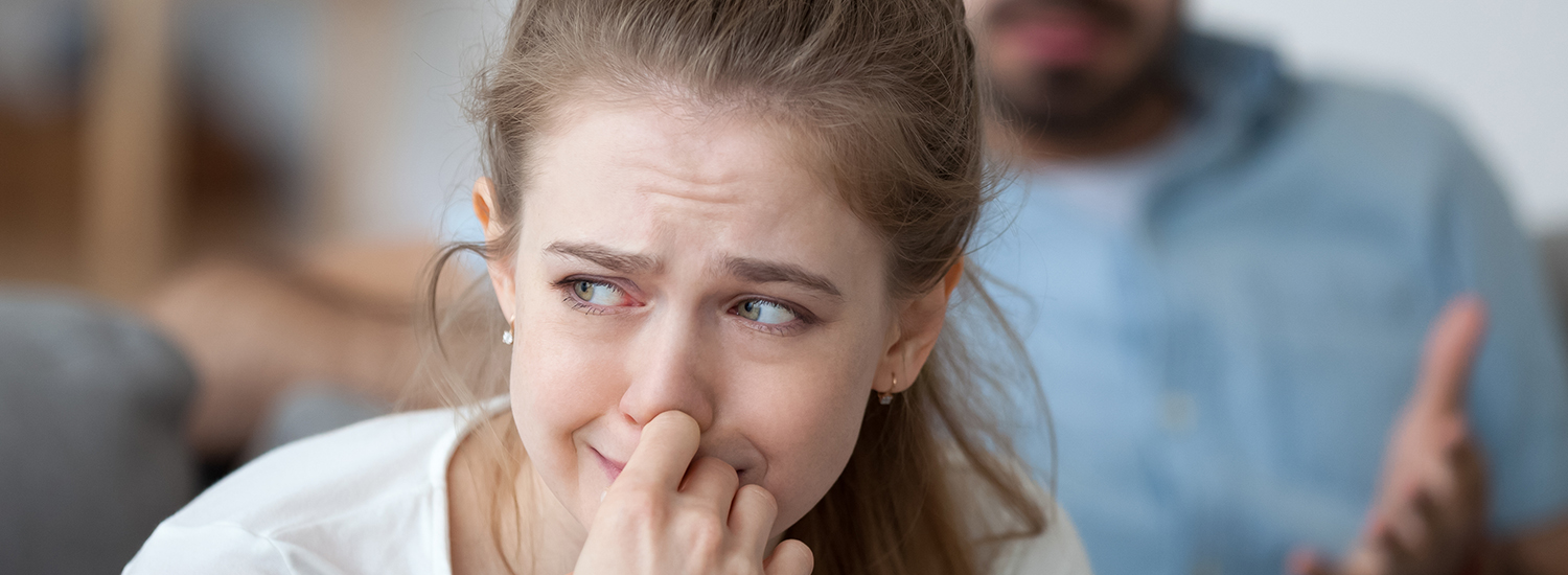 woman crying with man in background woman crying with man in background